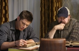 Bobby helps Dean with some research.